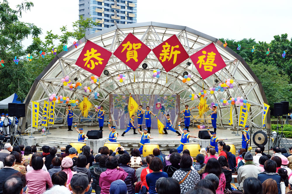 掛著「恭賀新禧」的社區舞台上，旗鼓隊正在演出